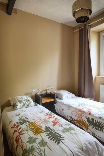une chambre avec deux lits et une fenêtre dans l'établissement Gîte ICI pour 8 personnes au bord de la rivière, à Le Monastier sur Gazeille