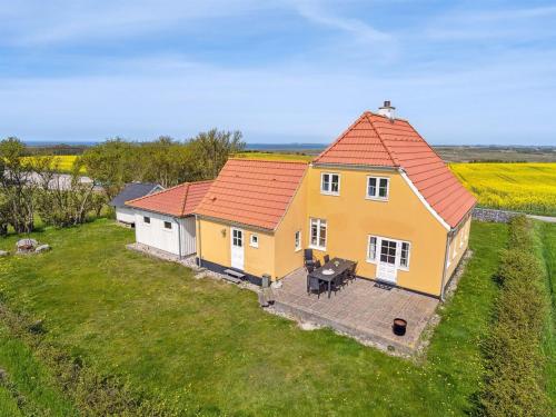 uma casa amarela com um telhado vermelho num campo em Holiday Home Store - 700m from the sea in Funen by Interhome em Ebberup