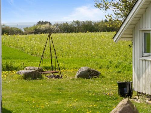 a field with rocks in the grass next to a house at Holiday Home Store - 700m from the sea by Interhome in Ebberup