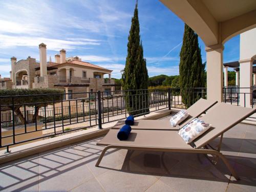 eine Terrasse mit einer Bank und Blick auf ein Haus in der Unterkunft Apartment Pine Hills Ambar by Interhome in Vilamoura