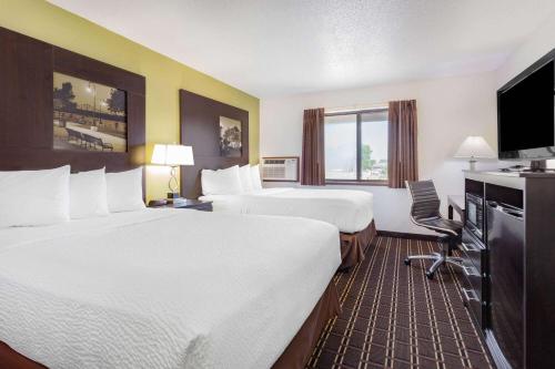 a hotel room with two beds and a flat screen tv at Super 8 by Wyndham La Crosse in La Crosse