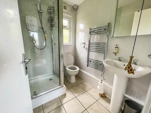 y baño con ducha, lavabo y aseo. en Beautiful Chalet With Free Wifi Nearby Hemsby Beach In Norfolk Ref 59096s, en Hemsby