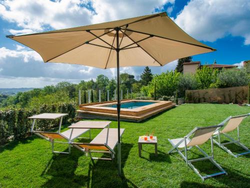a large umbrella and two chairs and a pool at Apartment Cinzia by Interhome in Santa Maria a Monte