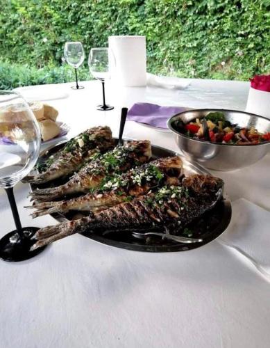 a plate of food on a table with wine glasses at Apartments Esperanza in Pašman