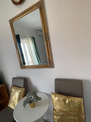 a mirror on a wall with a table and chairs at Apartments Esperanza in Pašman