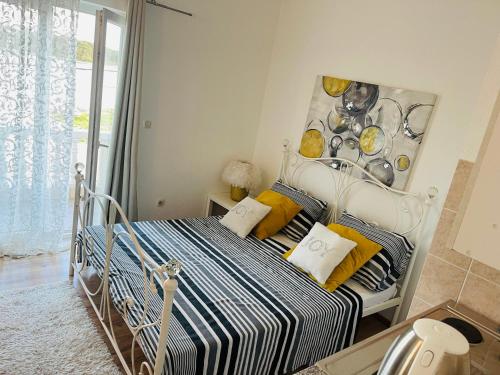 a bedroom with a bed with yellow and blue pillows at Apartments Esperanza in Pašman