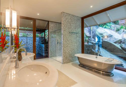 a large bathroom with a tub and a shower at Villa Salazie in Mahe