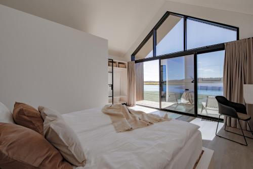 a bedroom with a bed and a large glass window at Vanduo Marse 