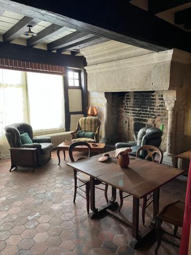 Maison des Acrobates في بلوا: غرفة معيشة مع طاولة ومدفأة