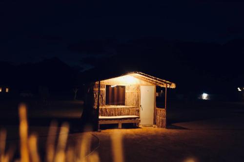 a small building with a lit up door at night at New Droub Camp in Nuweiba