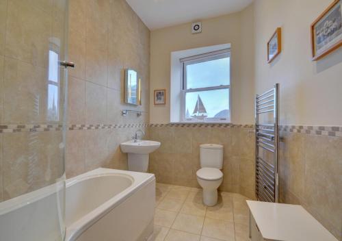 a bathroom with a tub and a toilet and a sink at 7 Cove View in Ilfracombe