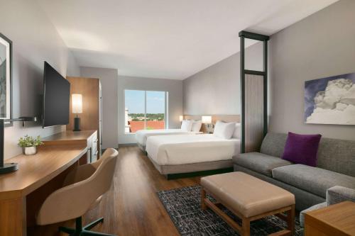 a hotel room with a bed and a couch at Hyatt Place Fort Worth/TCU in Fort Worth