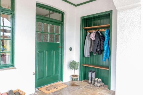 a green door on a white house with at Nutsford House in Dulverton