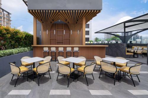 a restaurant with tables and chairs on a patio at Ramada Plaza by Wyndham Bangkok Sukhumvit 48 in Bangkok