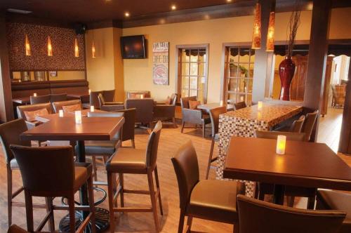 a restaurant with tables and chairs in a room at Atlantic Host Hotel, Trademark Collection by Wyndham in Bathurst