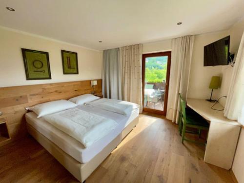 a bedroom with a large white bed and a desk at Pension Klimesch in Mondsee