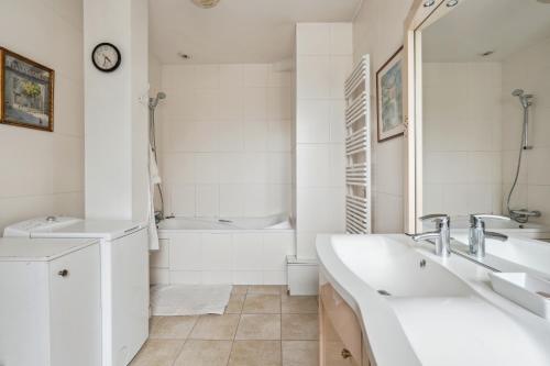a white bathroom with two sinks and a bath tub at Charming apt for 5 people in Paris by Weekome in Paris
