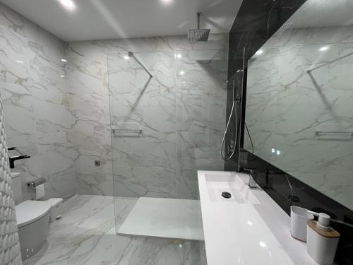 ein weißes Badezimmer mit Dusche und Waschbecken in der Unterkunft Villa Ribeiro By Keys to Algarve in Armação de Pêra