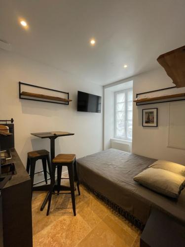 une chambre avec un lit, une table et un bureau dans l'établissement Petite chambre aménagée avec cuisine St Louis 3, à La Rochelle