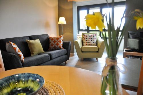 uma sala de estar com um sofá e uma mesa em Dolmenyn em Tenby