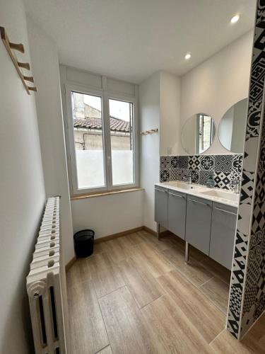 a bathroom with a sink and a large window at Maison de casteljaloux 9 personnes in Casteljaloux
