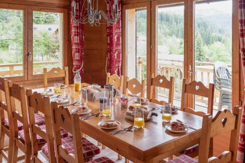 - une table en bois avec de la nourriture dans une chambre avec fenêtres dans l'établissement Chalet Celine, aux Gets