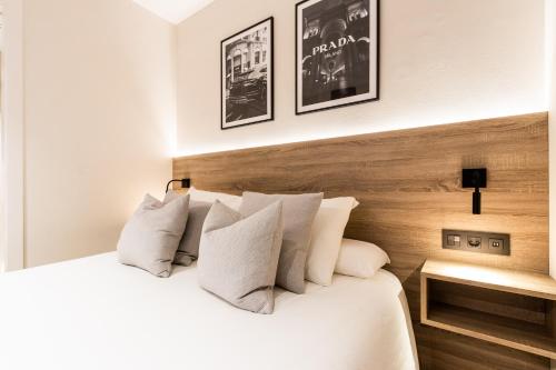 1 dormitorio con 1 cama con sábanas y almohadas blancas en Exclusive Apartments Barcelona 4 personas G Humet, en Terrassa