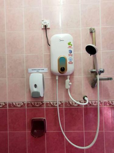 a soap dispenser on the wall of a bathroom at 88 Homestay Teluk Intan 5 minutes to Leaning Tower in Teluk Intan
