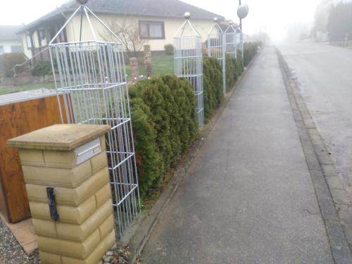 a sidewalk with a row of bird cages at Ferienwohnung Butz in Lottstetten