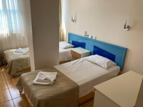 a hotel room with two beds and a mirror at Er-Öz Hotel in Fethiye