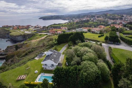 Vue aérienne d'une maison sur une colline près de l'eau dans l'établissement Impresionante villa sobre el mar en el mismo Comillas, à Comillas