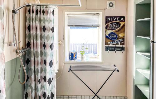 uma casa de banho com uma cortina de chuveiro e uma janela em Beautiful Home In Noresund With Kitchen em Noresund