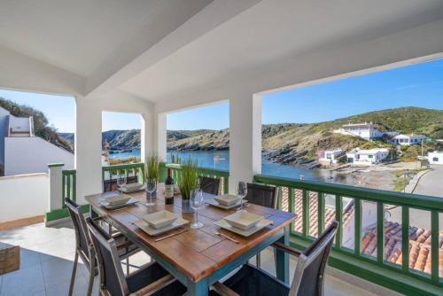 a dining room with a table and chairs and a balcony at Can Palanca in Cala Llonga