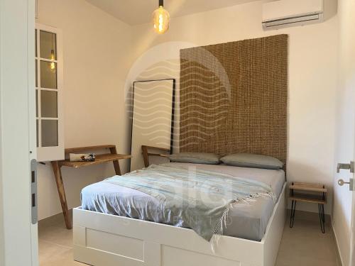 een slaapkamer met een bed met een hoofdeinde bij Villa Areia - Spiaggia a 10m By Cala Salento in Porto Cesareo