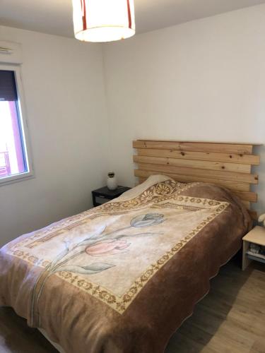 une chambre avec un grand lit avec une tête de lit en bois dans l'établissement T2 Bis avec Terrasse vue Montagne proche mer, commerces et Biarritz, à Bidart