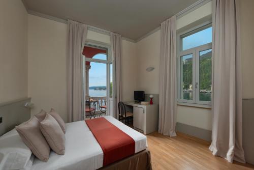 a bedroom with a bed and a large window at Hotel Milano in Toscolano Maderno