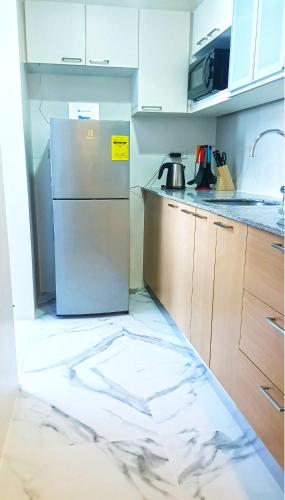 a kitchen with a refrigerator on the floor at Mactan Newtown - 1BR Stunning Ocean View and City View in Mactan