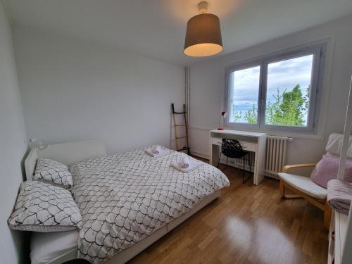 a bedroom with a bed and a desk and a window at Vue Lac, Central et Contemporain in Évian-les-Bains