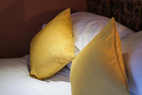 two yellow pillows sitting on top of a bed at Craig Walk Suite in Bowness-on-Windermere