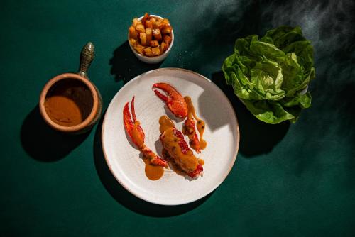 a plate of food witharters and a bowl of lettuce at The Headland Hotel and Spa in Newquay