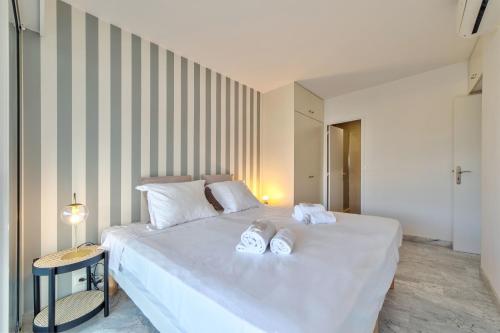 une chambre avec un lit blanc avec des serviettes dessus dans l'établissement Appartement Canto bright appartement Croisette beach, à Cannes