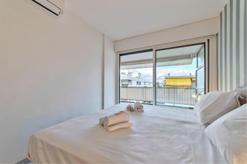 - une chambre blanche avec un lit et une grande fenêtre dans l'établissement Appartement Canto bright appartement Croisette beach, à Cannes