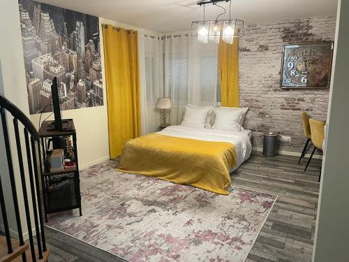 1 dormitorio con cama y pared de ladrillo en Lodgespa : Maison Rose, en Hésingue