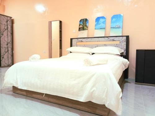 1 dormitorio con 2 camas con sábanas y almohadas blancas en Tropical stay Thulusdhoo, en Thulusdhoo