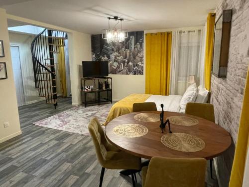 Habitación con mesa, sillas y cama en Lodgespa : Maison Rose, en Hésingue