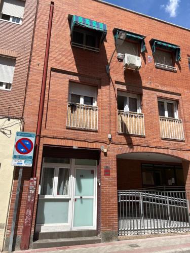 a red brick building with windows and a door at Bonito Apto Cinco Torres Plaza Castilla in Madrid