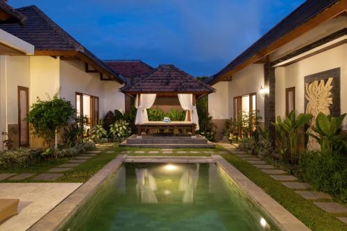 a villa with a swimming pool in front of a house at Villa Lapiz Lazuli Seminyak Kuta in Seminyak