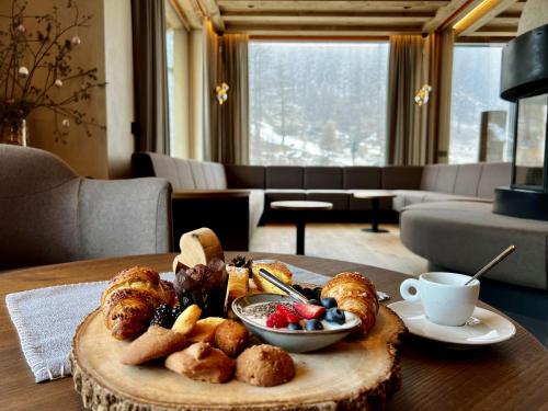 a tray of pastries and fruit on a table at Camino Rustic Chic Hotel in Livigno