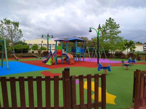 een park met een speeltuin met glijbanen en schommels bij CHRISTINA'S GARDEN HOUSE in Perea
