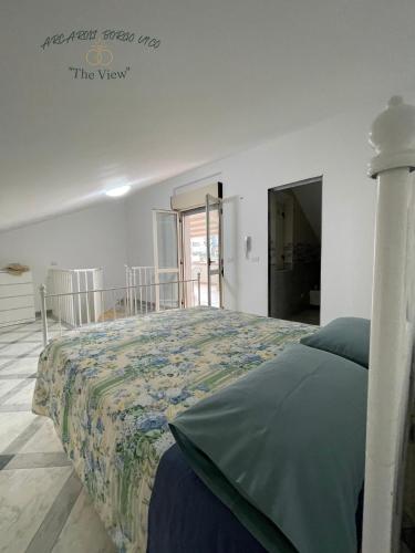 1 Schlafzimmer mit einem Bett mit Blumenbettdecke in der Unterkunft Arcaroli Borgo Vico "The View" in Vico del Gargano